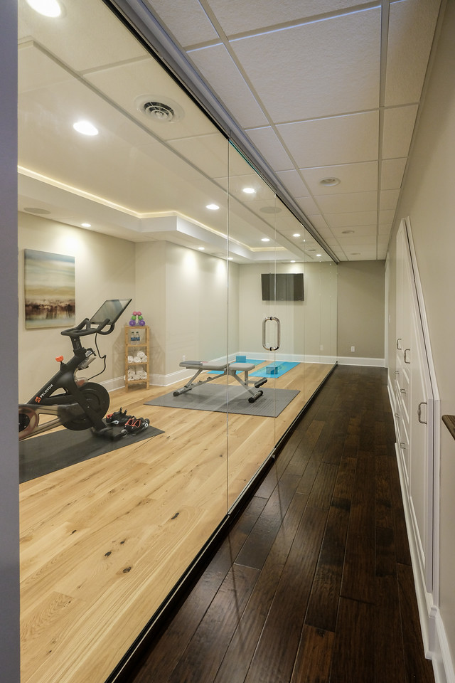 Immagine di uno studio yoga minimal con pareti grigie, parquet chiaro e pavimento beige