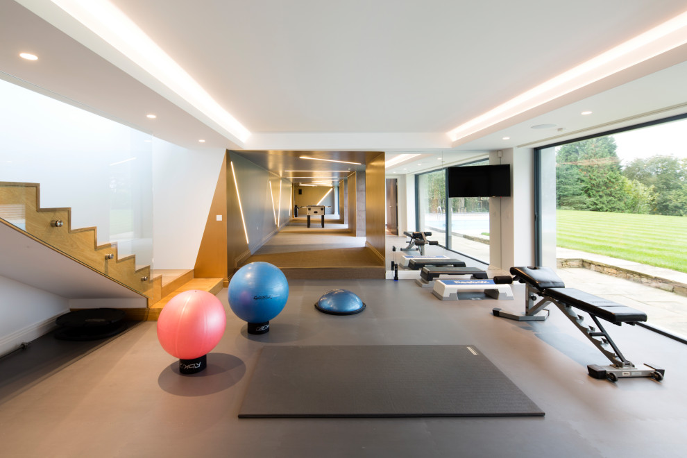 Design ideas for an expansive contemporary multi-use home gym in London with grey floors.