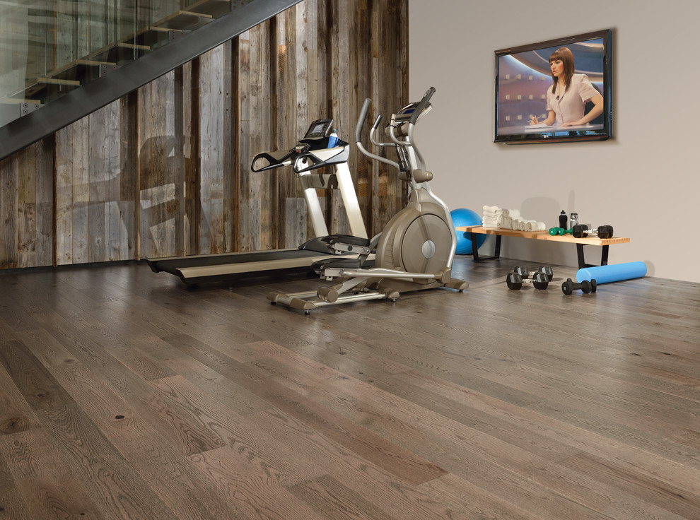 Example of a large minimalist medium tone wood floor multiuse home gym design in New York with brown walls