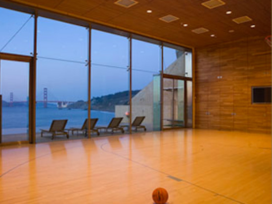 Großer Fitnessraum mit Indoor-Sportplatz, brauner Wandfarbe und hellem Holzboden in San Francisco