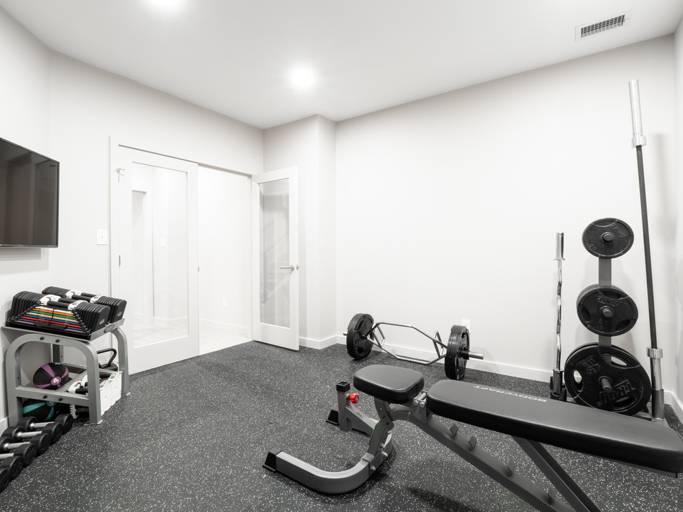 Multifunktionaler, Mittelgroßer Moderner Fitnessraum mit weißer Wandfarbe und schwarzem Boden in Sonstige