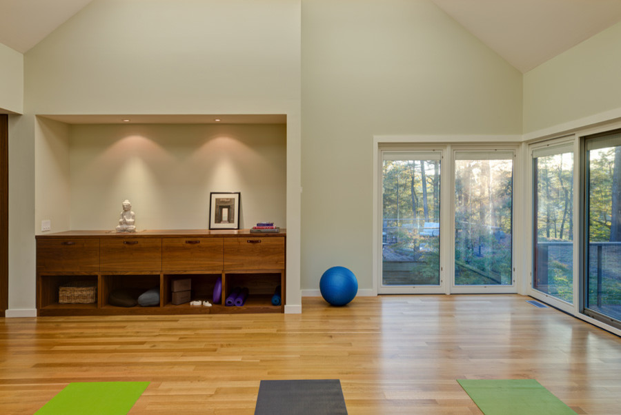 На фото: большая йога-студия в стиле модернизм с серыми стенами и светлым паркетным полом с