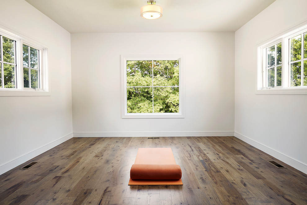 Photo of a medium sized farmhouse home yoga studio in Other with white walls and medium hardwood flooring.