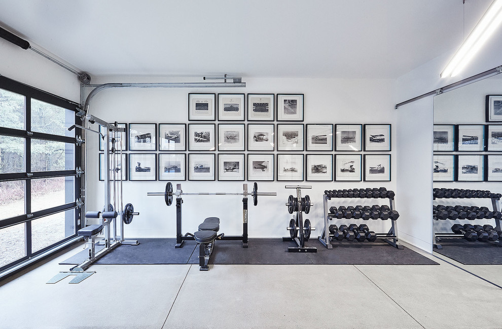 Moderner Fitnessraum mit weißer Wandfarbe, Betonboden und grauem Boden in Toronto