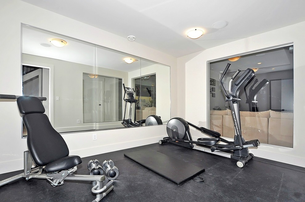 Photo of an urban multi-use home gym in Calgary with grey walls and black floors.
