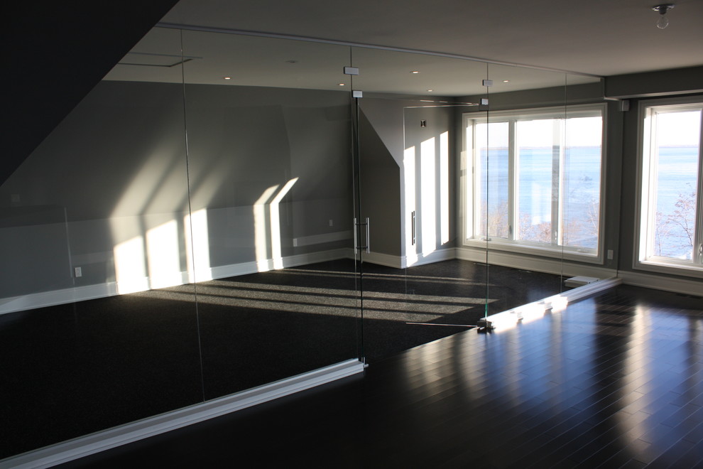 Immagine di una palestra in casa minimalista con pavimento nero