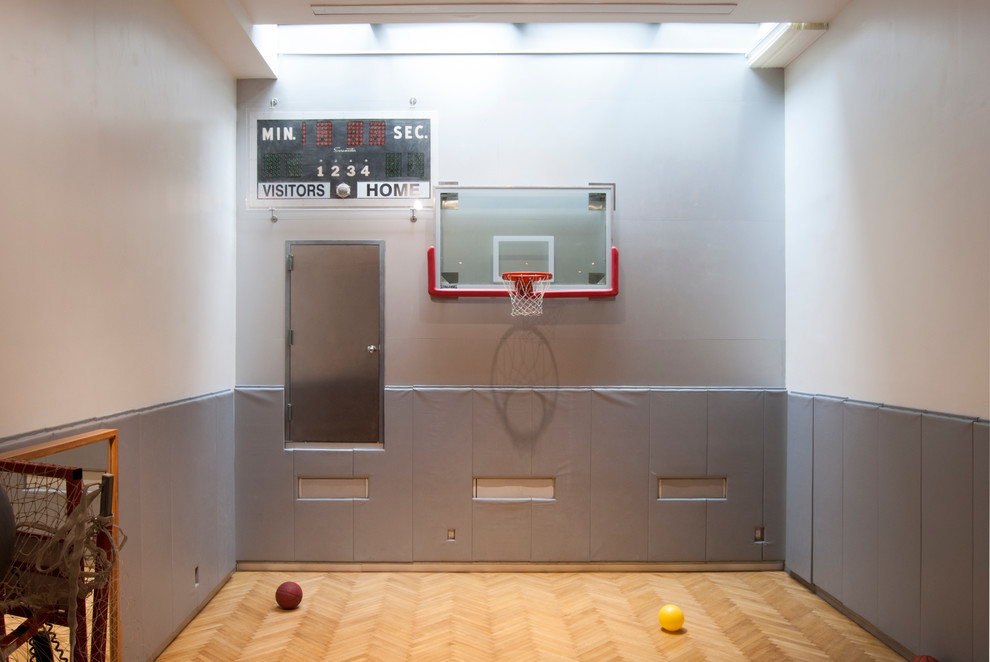 Großer Moderner Fitnessraum mit Indoor-Sportplatz, grauer Wandfarbe und hellem Holzboden in New York