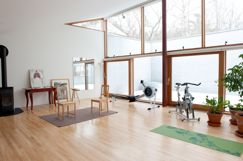 Multifunktionaler, Großer Moderner Fitnessraum mit weißer Wandfarbe und hellem Holzboden in Burlington