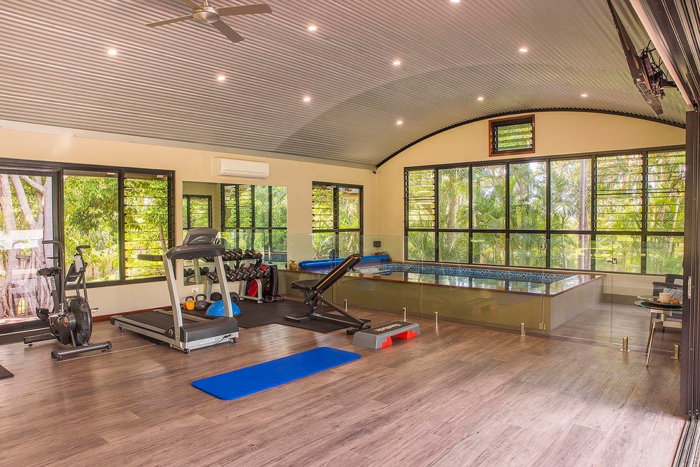 Inspiration for a large world-inspired multi-use home gym in Sunshine Coast with beige walls and brown floors.