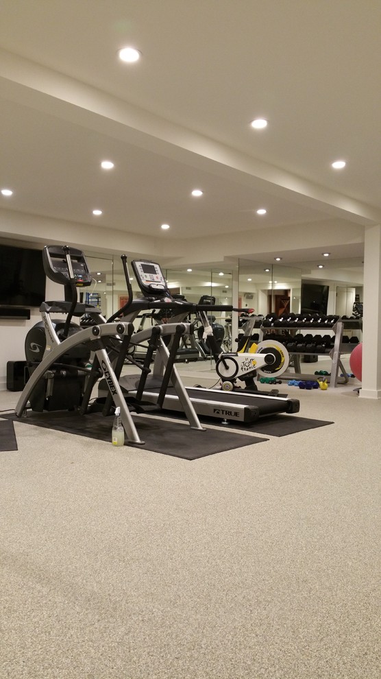 This is an example of a large traditional multi-use home gym in New York with white walls and carpet.