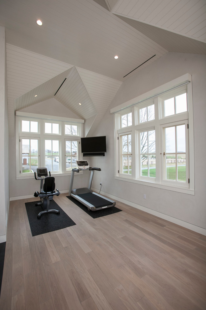 Moderner Fitnessraum mit weißer Wandfarbe und hellem Holzboden in Sonstige