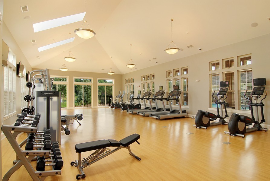 Exemple d'une très grande salle de sport craftsman multi-usage avec un mur gris et parquet clair.
