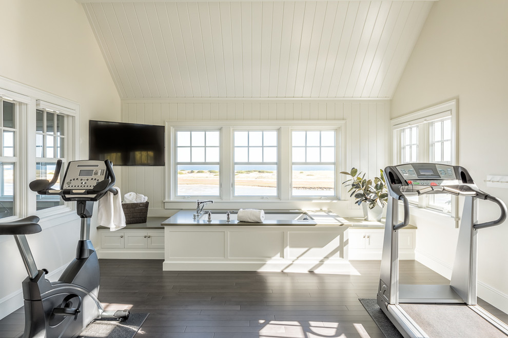 Photo of a coastal multi-use home gym in Portland Maine with white walls and dark hardwood flooring.