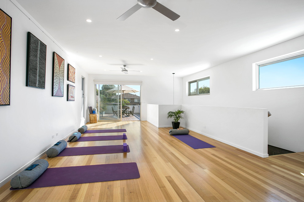 Idee per uno studio yoga minimal con pareti bianche e parquet chiaro