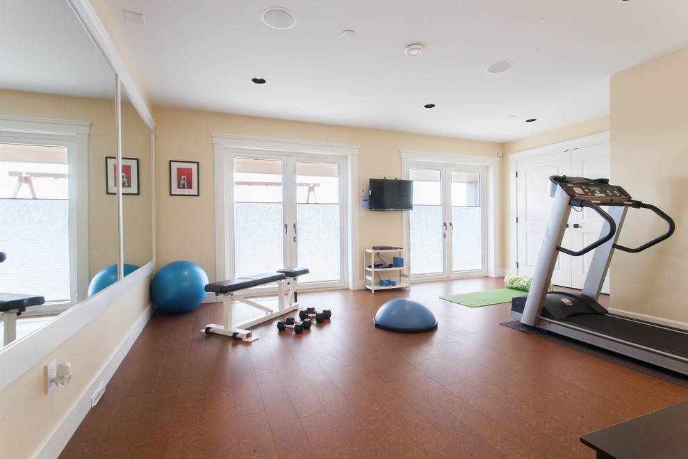 Multifunktionaler Klassischer Fitnessraum mit gelber Wandfarbe und braunem Boden in Vancouver