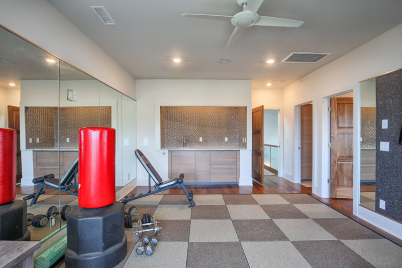 Foto de sala de pesas minimalista de tamaño medio con paredes blancas, suelo de madera en tonos medios y suelo marrón