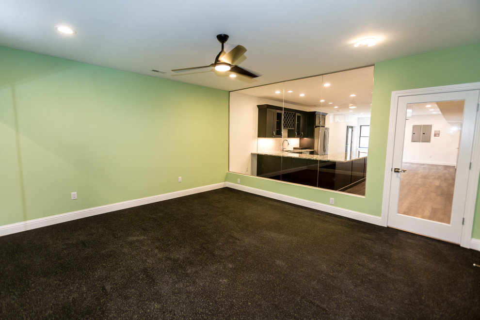 Multifunktionaler, Großer Klassischer Fitnessraum mit grüner Wandfarbe und schwarzem Boden in St. Louis