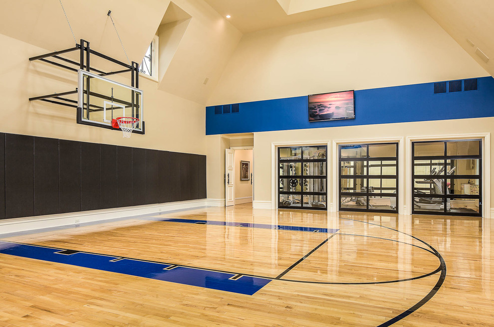 Geräumiger Klassischer Fitnessraum mit Indoor-Sportplatz, beiger Wandfarbe und hellem Holzboden in Dallas