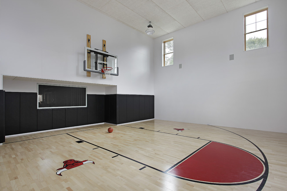 Moderner Fitnessraum mit Indoor-Sportplatz, weißer Wandfarbe und hellem Holzboden in Chicago
