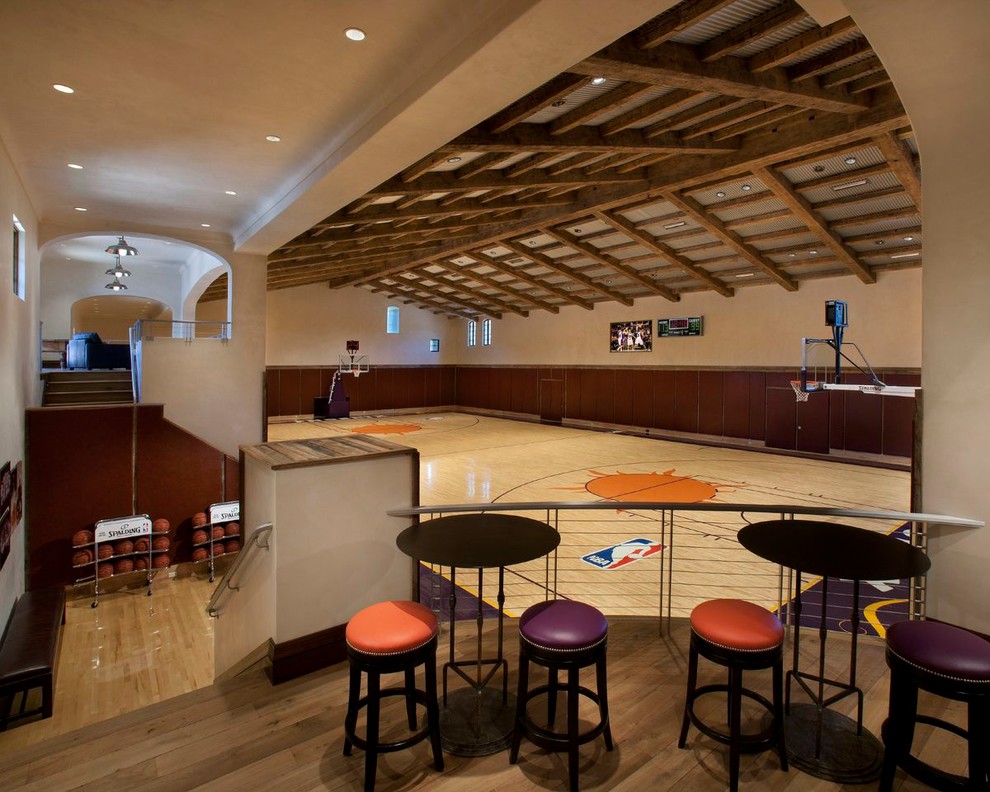 Geräumiger Mediterraner Fitnessraum mit Indoor-Sportplatz, beiger Wandfarbe und hellem Holzboden in Phoenix