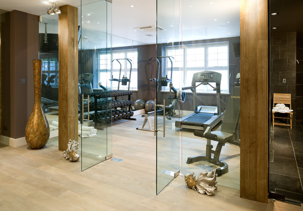 Example of a mid-sized trendy light wood floor and beige floor home gym design in Dublin with brown walls