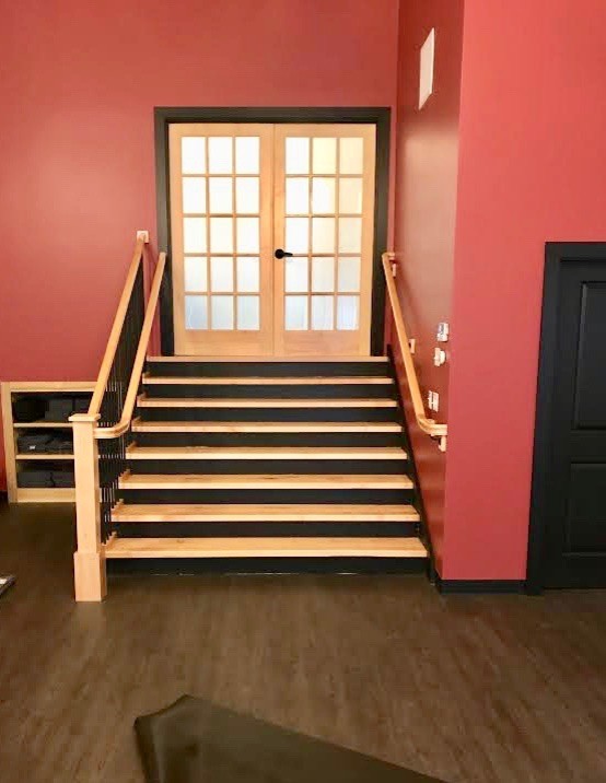 Multifunktionaler, Geräumiger Klassischer Fitnessraum mit roter Wandfarbe, dunklem Holzboden und braunem Boden in Boston