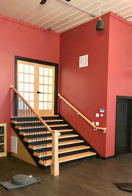 Foto di un'ampia palestra multiuso tradizionale con pareti rosse, parquet scuro e pavimento marrone