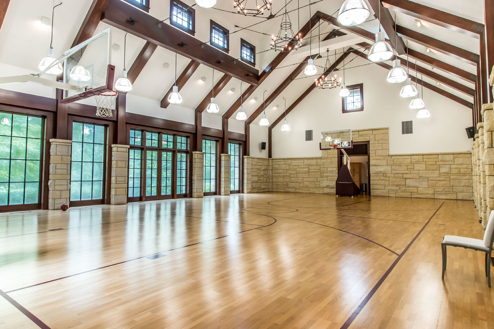 Klassischer Fitnessraum mit Indoor-Sportplatz, weißer Wandfarbe, braunem Holzboden und braunem Boden in Detroit