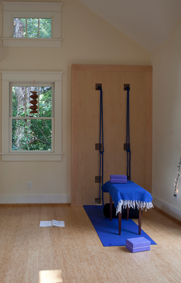 Exemple d'un studio de yoga méditerranéen avec parquet en bambou et un mur jaune.