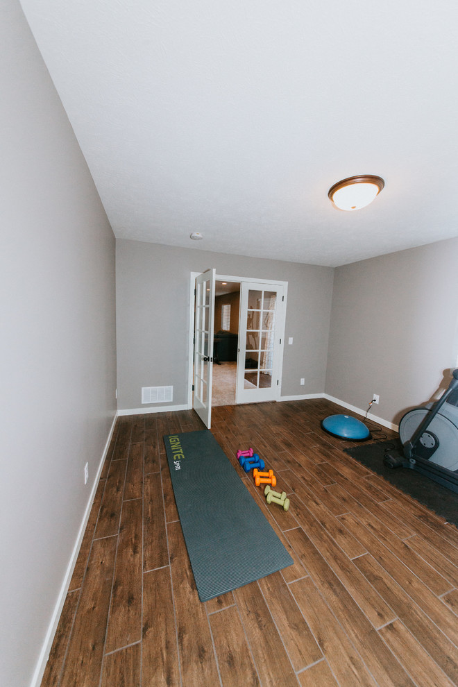 Multifunktionaler, Mittelgroßer Klassischer Fitnessraum mit grauer Wandfarbe, braunem Holzboden und braunem Boden in Omaha