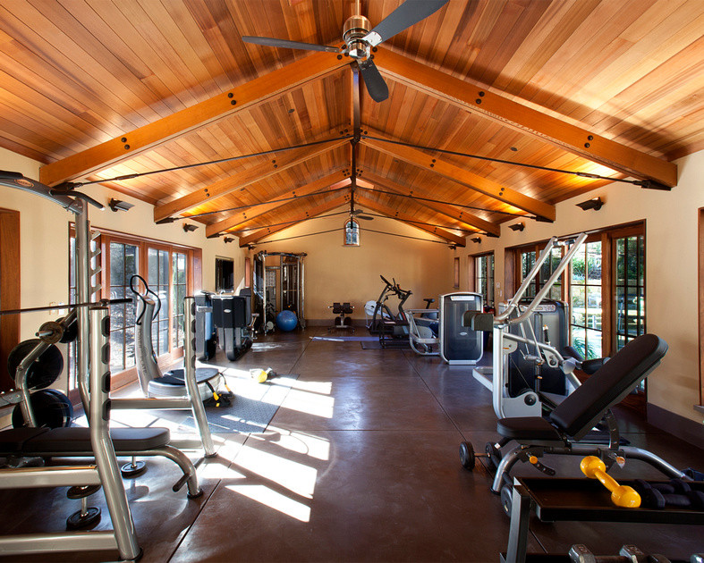 Photo of a large contemporary multi-use home gym in San Francisco with beige walls, concrete flooring and brown floors.
