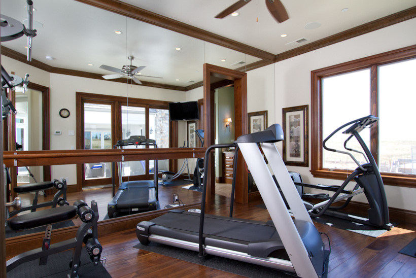 Example of a mid-sized classic medium tone wood floor home gym design in Sacramento with white walls