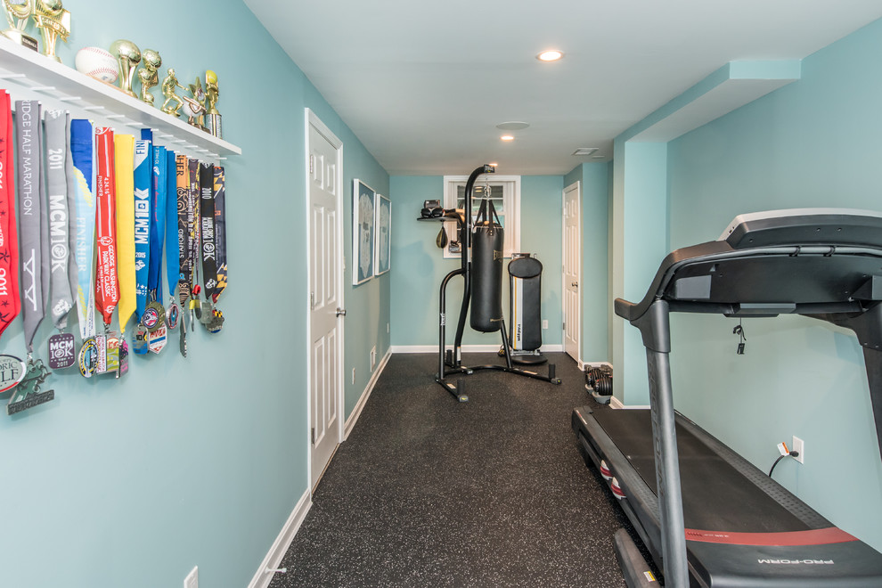 Design ideas for a small classic multi-use home gym in DC Metro with blue walls and black floors.