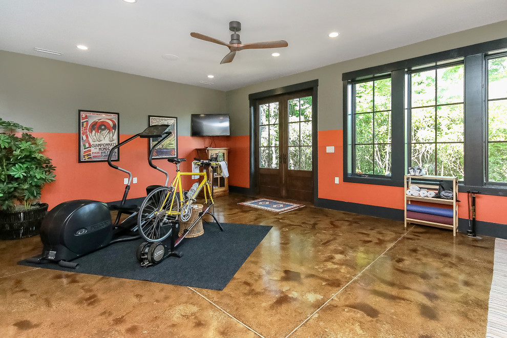 Inredning av ett klassiskt mellanstort hemmagym med yogastudio, med orange väggar, betonggolv och brunt golv