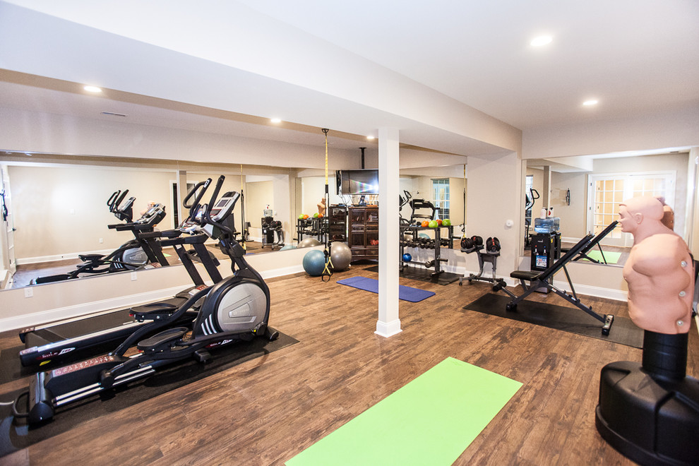 Multi-use home gym in St Louis with beige walls and dark hardwood flooring.