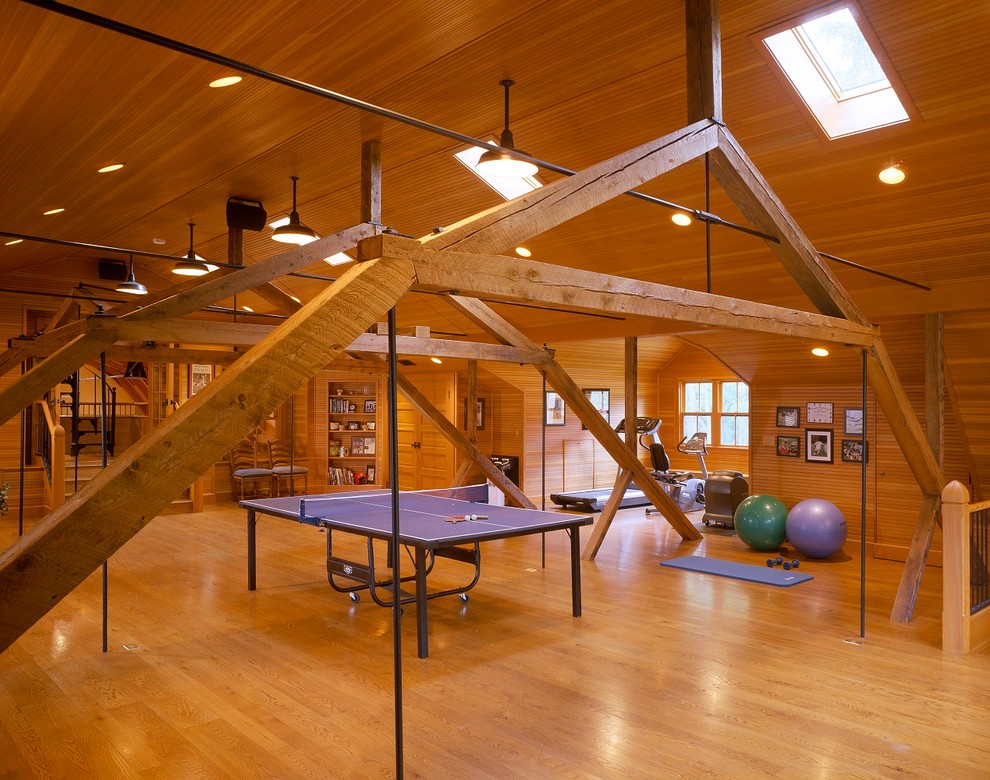 Expansive country multi-use home gym in Boston with medium hardwood flooring, brown walls and feature lighting.