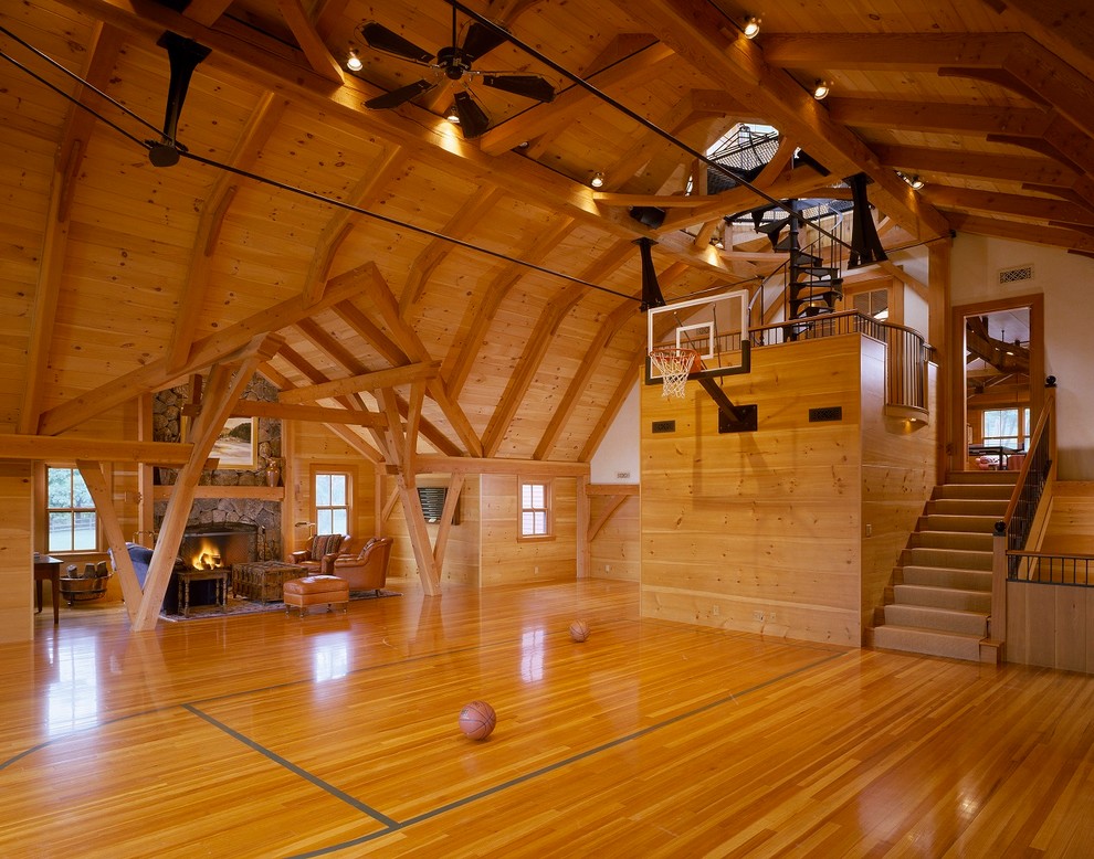 Geräumiger Landhaus Fitnessraum mit Indoor-Sportplatz, braunem Holzboden und brauner Wandfarbe in Boston