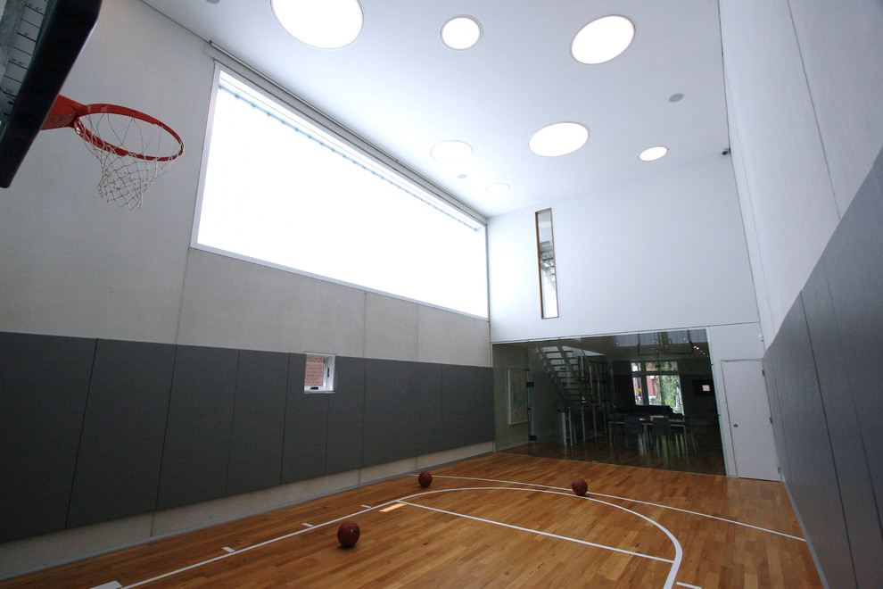 Mittelgroßer Moderner Fitnessraum mit Indoor-Sportplatz, grauer Wandfarbe und braunem Holzboden in Chicago