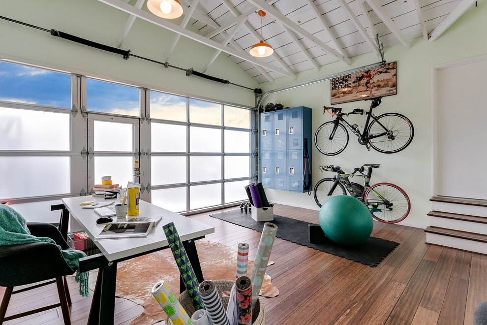 This is an example of a medium sized contemporary home yoga studio in Los Angeles with green walls, medium hardwood flooring and brown floors.