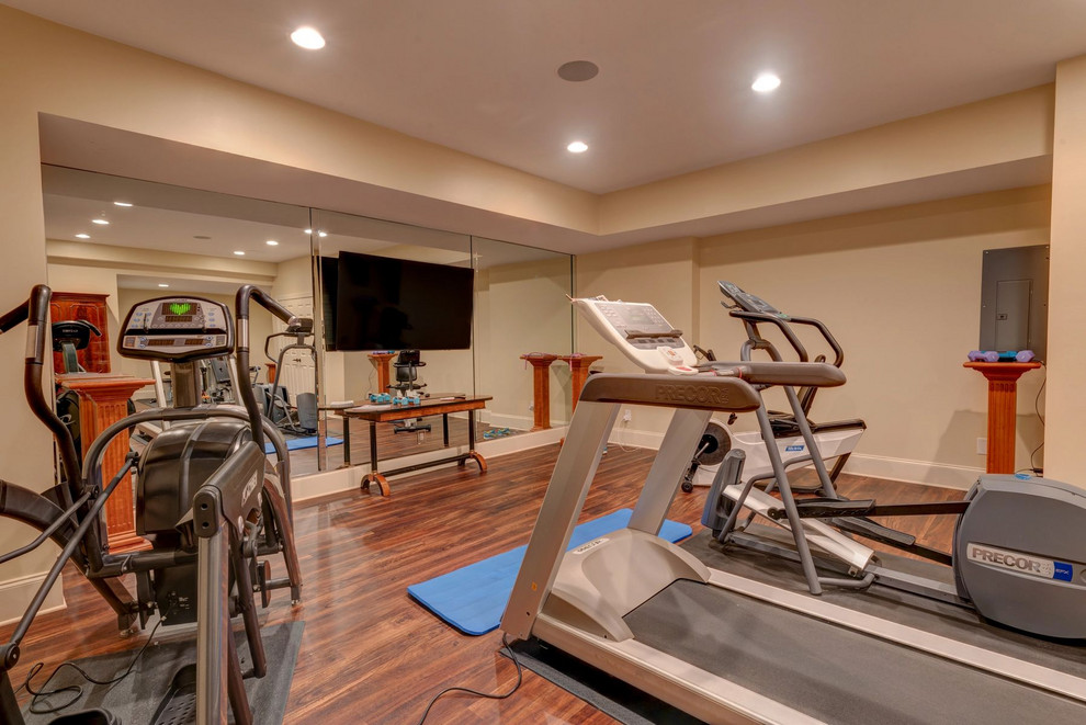 Photo of a large traditional home weight room in Nashville with beige walls, dark hardwood flooring and brown floors.