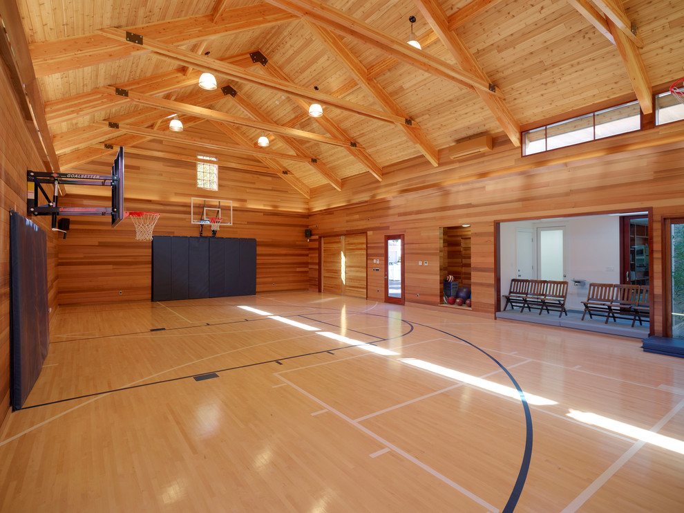 На фото: большой спортзал в стиле неоклассика (современная классика) с светлым паркетным полом, бежевым полом и коричневыми стенами с