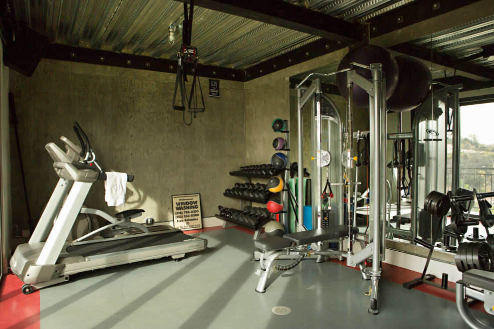 Foto de sala de pesas tradicional de tamaño medio con suelo de cemento