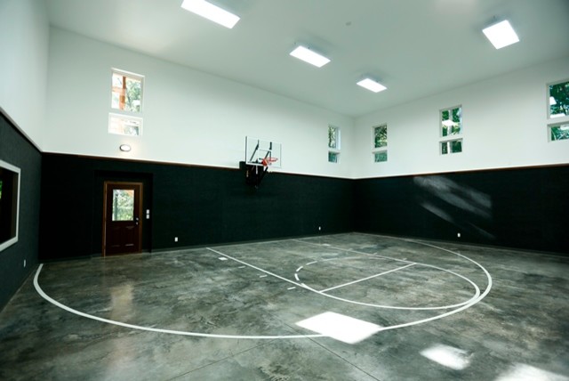 На фото: большой спортзал в стиле рустика с разноцветными стенами и бетонным полом