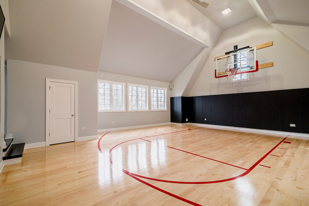 Großer Klassischer Fitnessraum mit Indoor-Sportplatz, beiger Wandfarbe und hellem Holzboden in Chicago