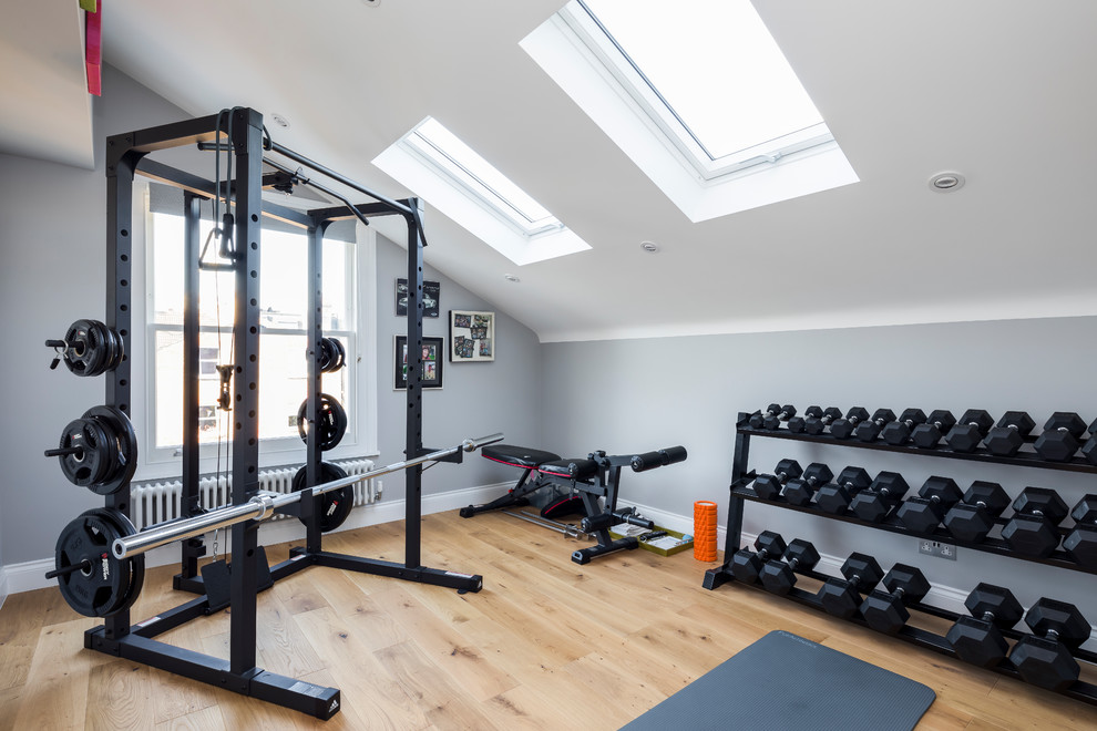 Multifunktionaler, Mittelgroßer Moderner Fitnessraum mit grauer Wandfarbe, hellem Holzboden und beigem Boden in London