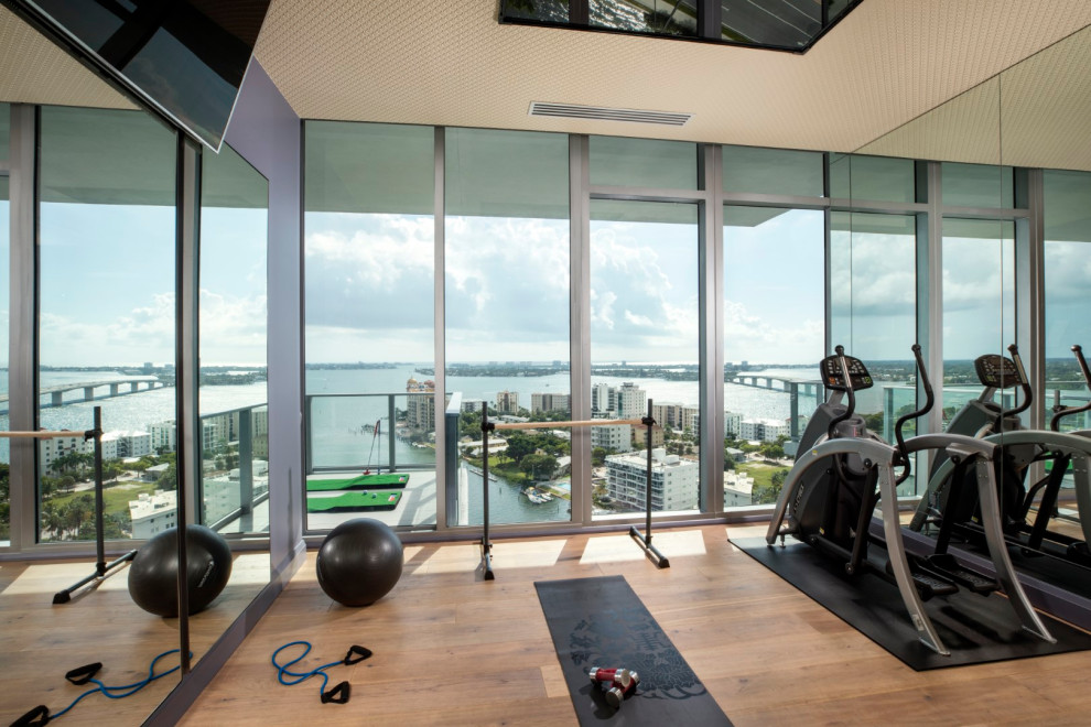Moderner Fitnessraum mit dunklem Holzboden und braunem Boden in Tampa
