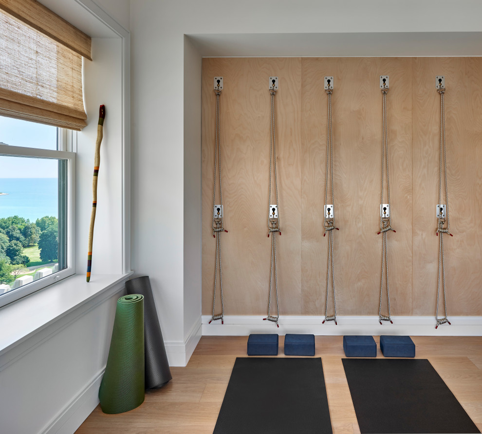 Idee per uno studio yoga tradizionale con pareti bianche, parquet chiaro e pavimento marrone