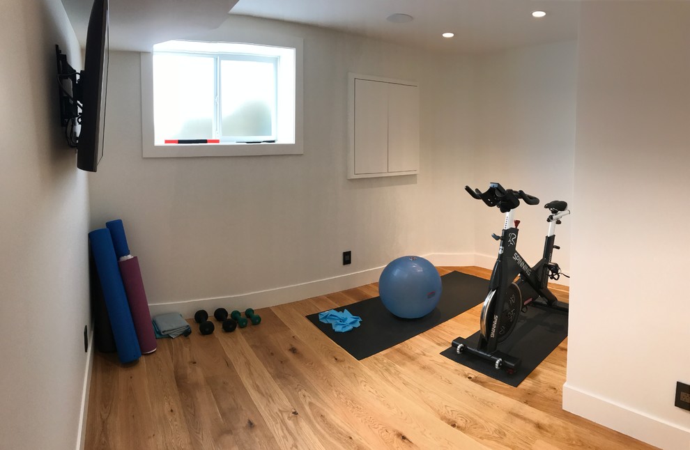 Inspiration for a medium sized modern home gym in Calgary with white walls and medium hardwood flooring.