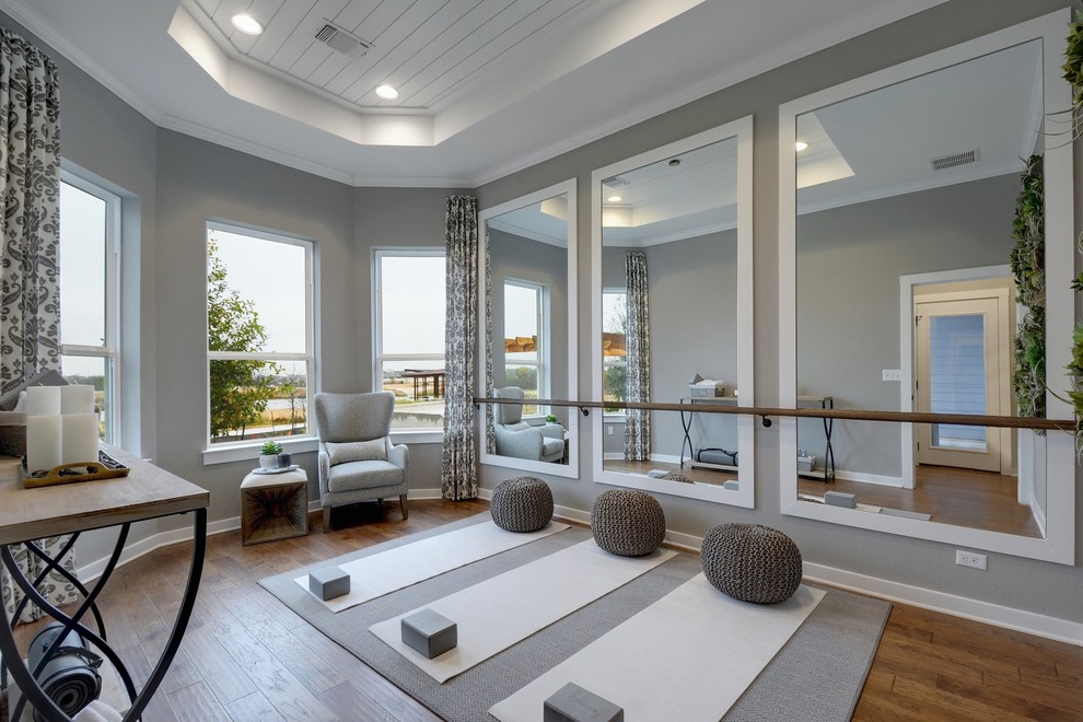 Example of a transitional medium tone wood floor and brown floor home yoga studio design in Jacksonville with gray walls