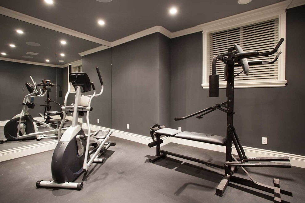 Réalisation d'une salle de musculation minimaliste de taille moyenne avec un mur gris et un sol noir.